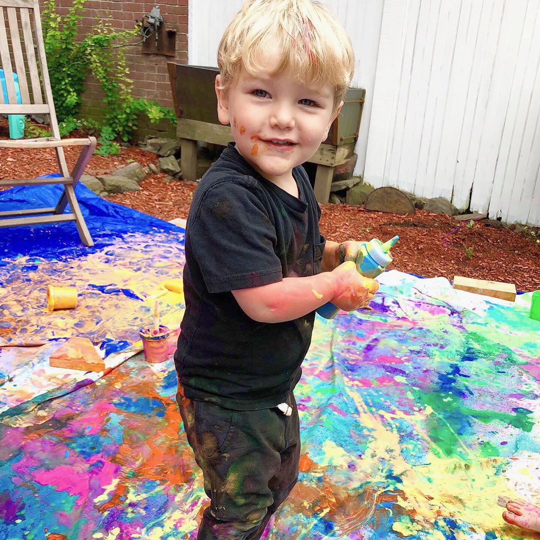 Child squeezing paint onto mural - is art important