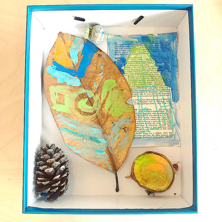 Painted leaf, pinecone adn piece of wood and paper for nature diorama
