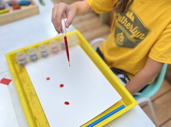 use pipette to drop paint onto paper